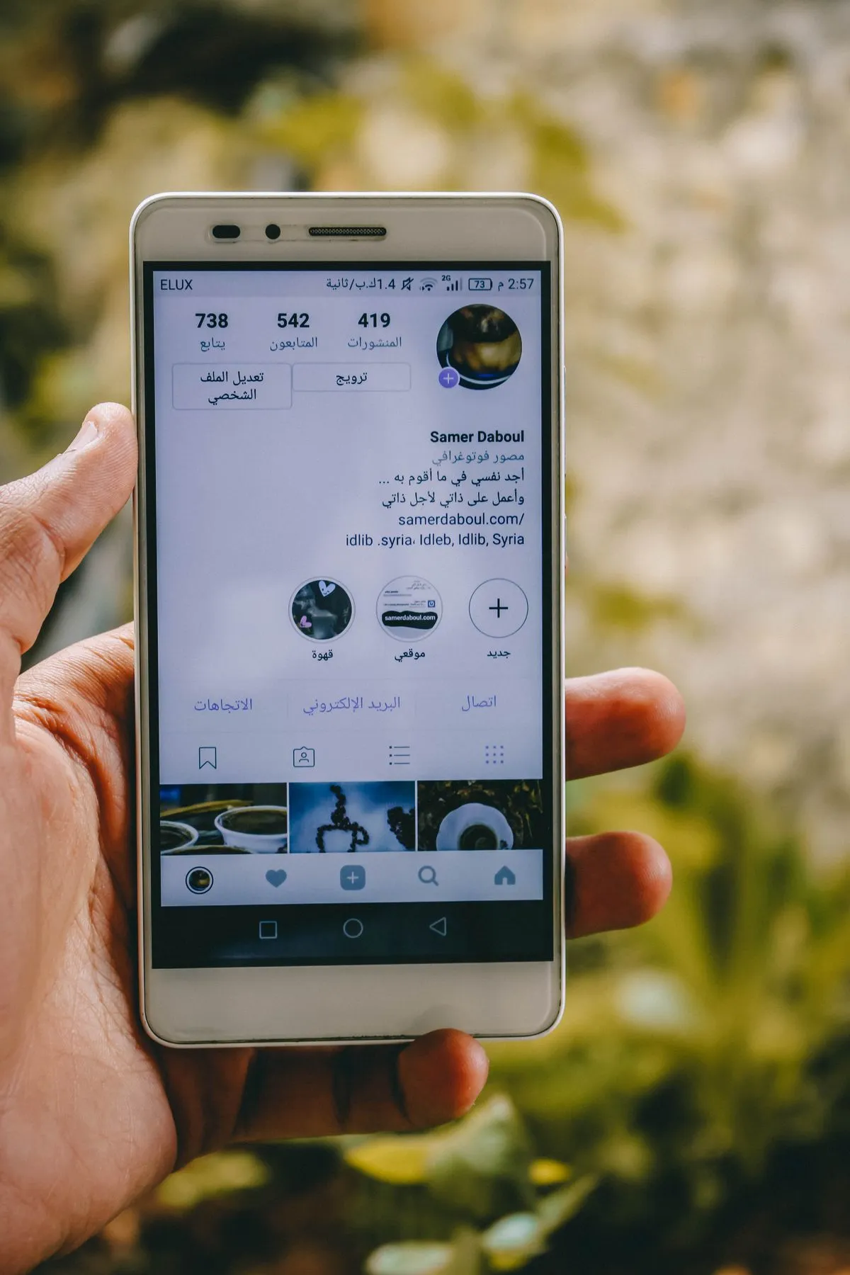 Hand holding a phone while reviewing a social media profile