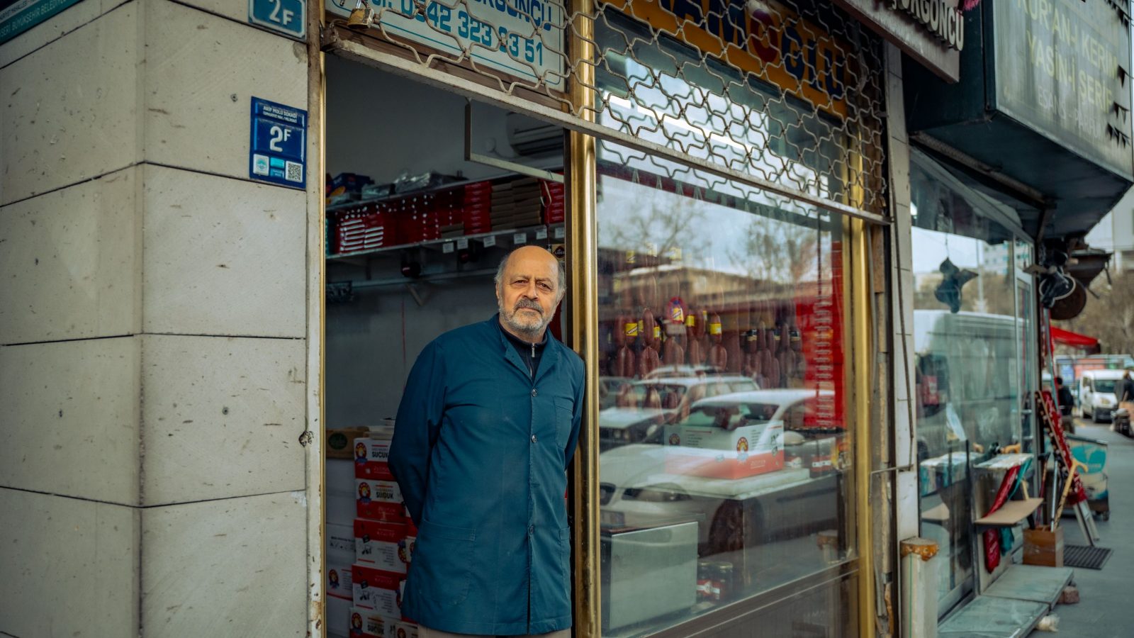 Dükkânının girişinde duran yerel işletme sahibi